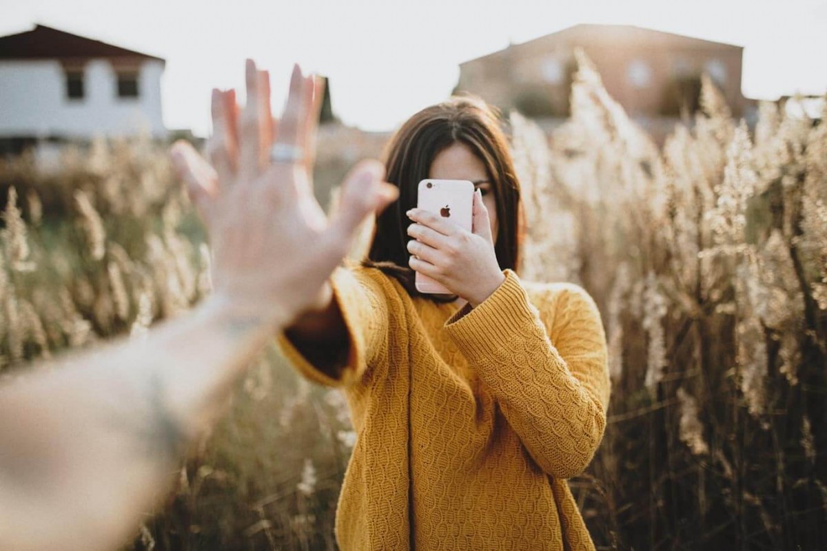 Perempuan sedang mengambil foto untuk diunggah di Stories maupun Feed Instagram